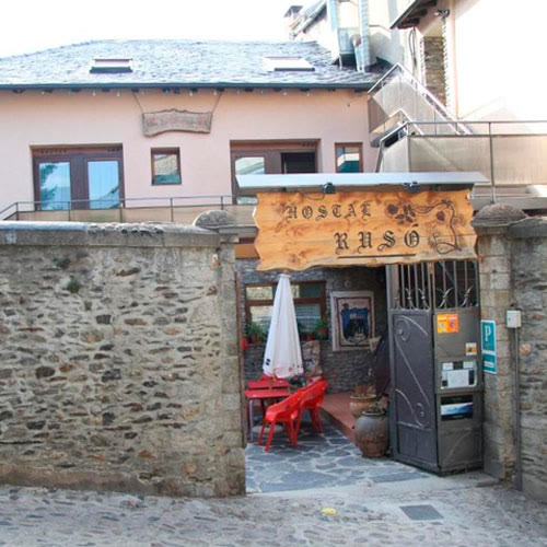 Entrada de l'Hostal Rusó amb el senyal d'aparcament públic al costat