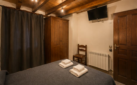 Habitació individual amb llit, armari i televisió